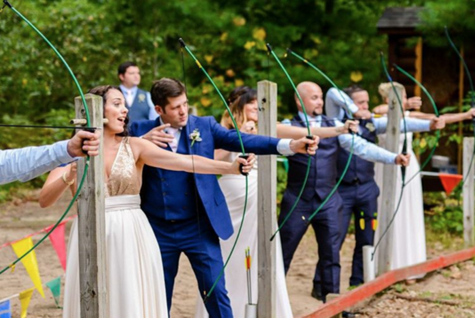 bride and groom shooting a bow and arrow