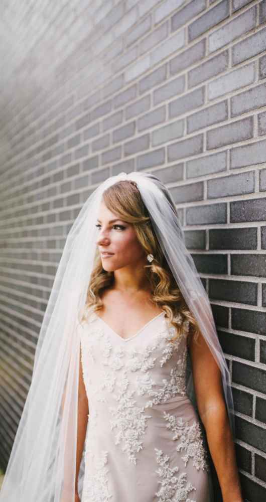 bride in front of brick wall
