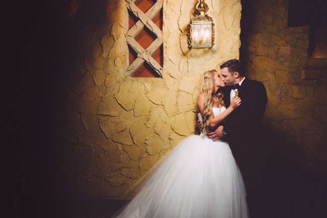 Bride & Groom Kiss in Front of a Textured Wall