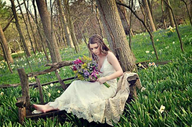 Bride seated on park bench
