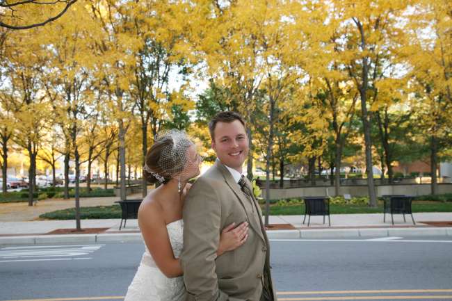 Bride Embracing Groom Under Fall Trees