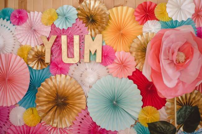 Gold "Yum" Sign on Paper Floral Background Decor