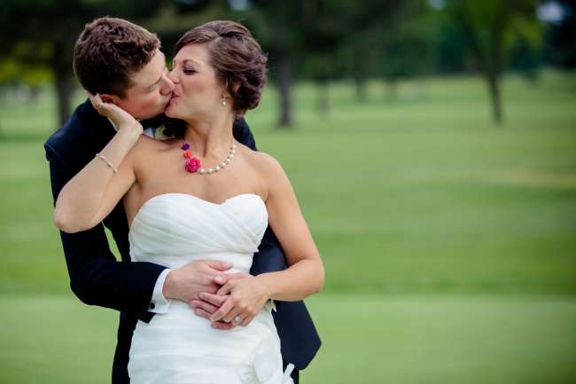 Bride in Bold, Colorful Necklace Kisses Her Groom