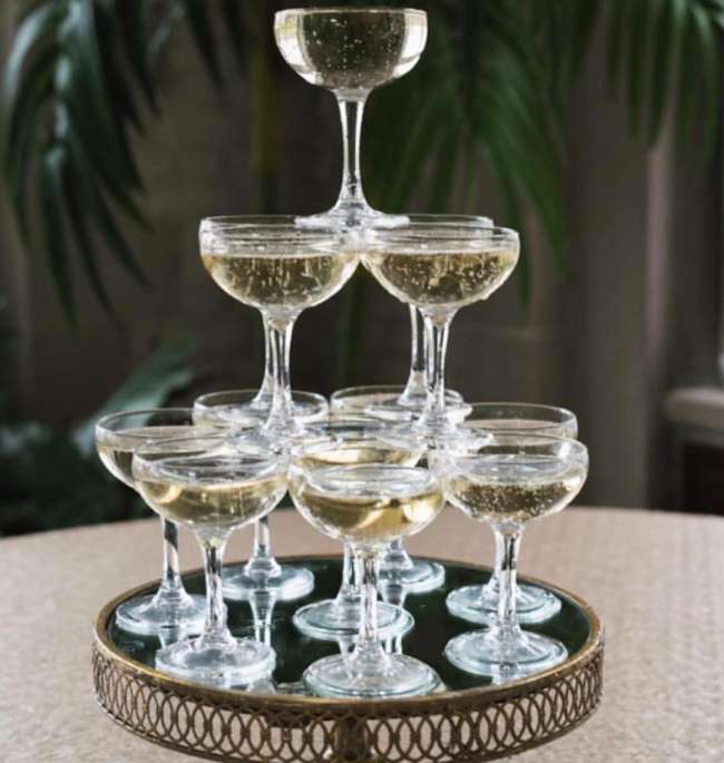 Champagne Coupes stacked on top of a cake stand