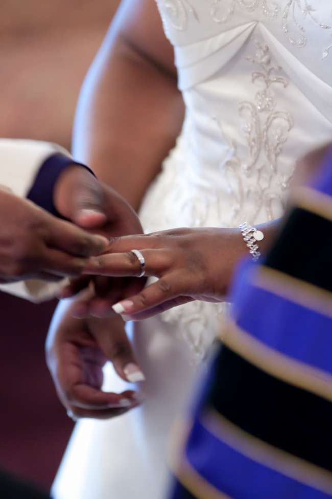 Groom Puts Ring on His Bride