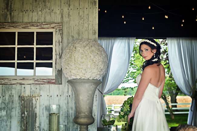 Bride in Barn With Large Floral Centerpiece