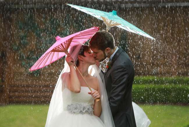 Bride & Groom Under Parasols in the Rain