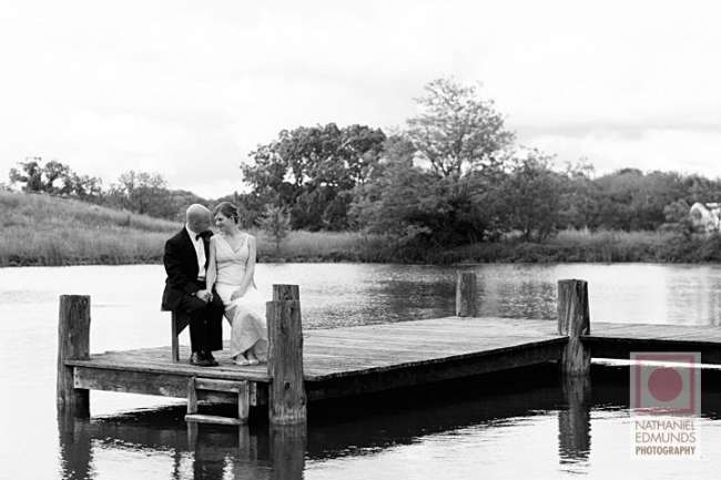 Bride and groom on lakeside dock
